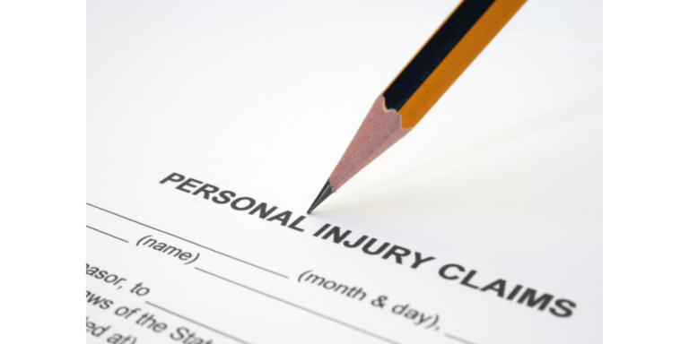 A sharpened pencil rests on a personal injury claims form, with blank spaces for name and date visible.
