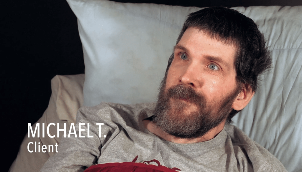 A bearded man with short brown hair lies in bed, looking up. Text on the image reads “MICHAEL T. Client.”.